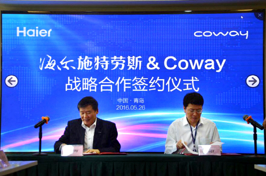 코웨이는 5월 26일 중국 칭다오에서 하이얼과 중국 정수기 시장 공략을 위해 전략적 판매 제휴 양해각서(MOU)를 체결했다고 지난달 31일 밝혔다. 김용성 코웨이 해외사업본부장(왼쪽)과 씨에 쥐 즐 하이얼 부총재가 MOU를 체결하고 있는 모습.  코웨이 제공